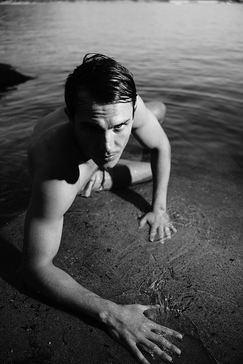 Portraits of male model by lake in black and white 