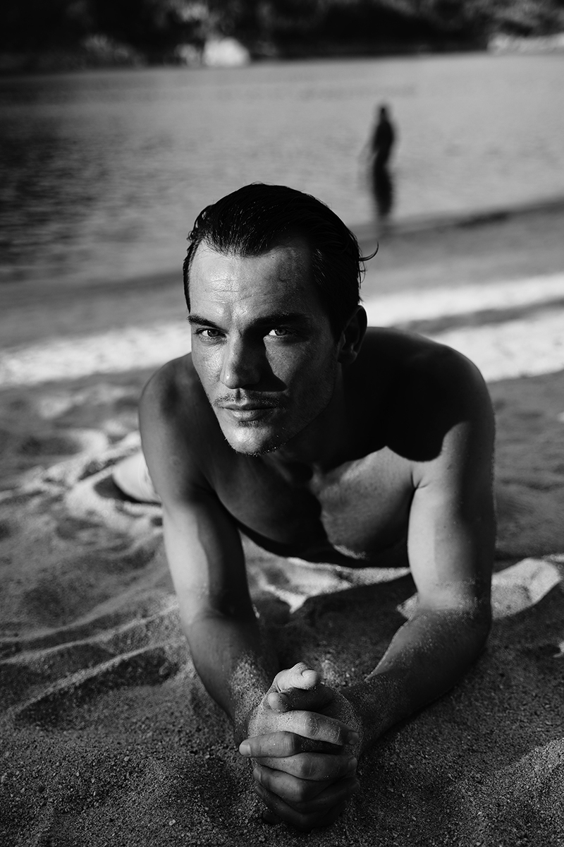 Portraits of male model by lake in black and white 
