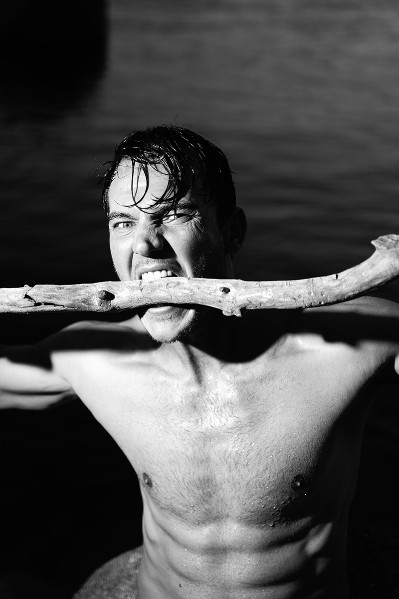 Portraits of male model by lake in black and white 