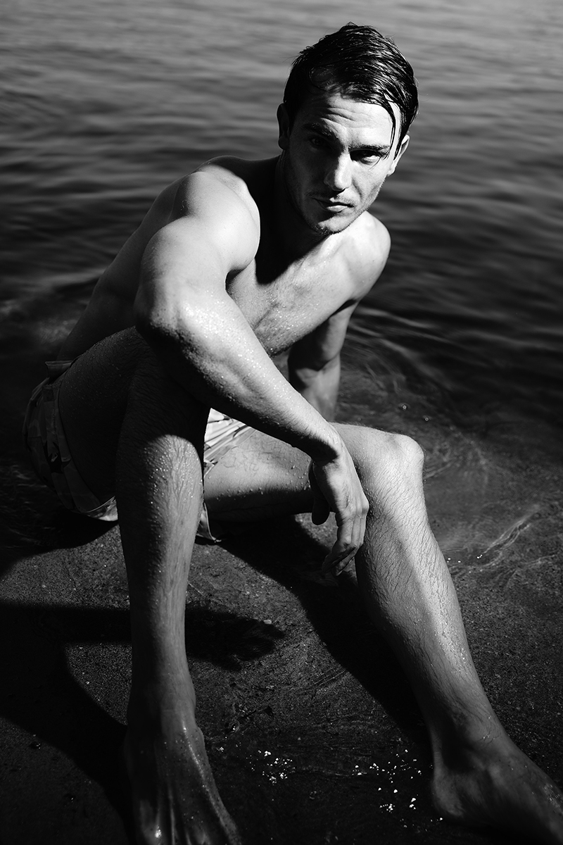 Portraits of male model by lake in black and white 